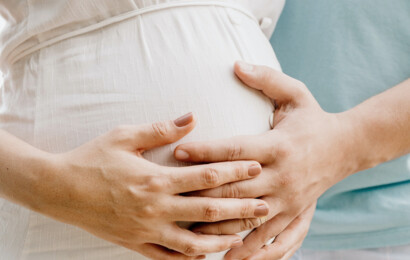 Eine Frau streichelt liebevoll ihren Babybauch